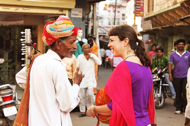 A foreign girl talking to a local folk musician in Pushkar