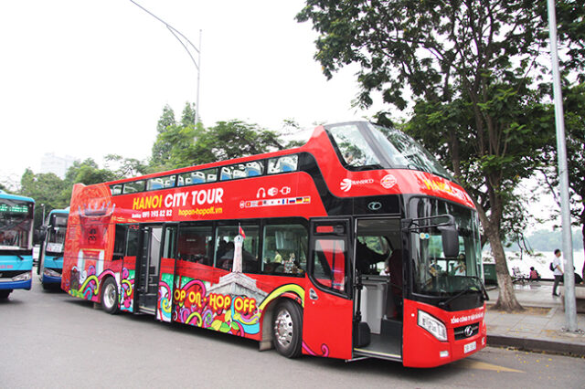 A two-stage bus waiting to pick up passengers at Hoan Kiem Lake, Hanoi
