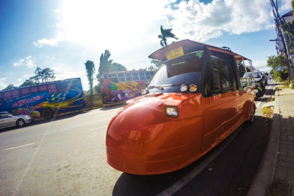 An orange Tuk-tuk on the street of Ayutthaya